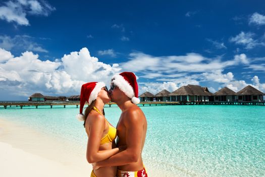 Couple in santa's hat on a tropical beach at Maldives