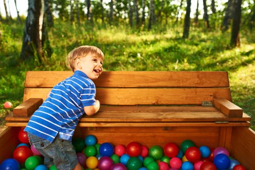 Happy child playing at colorful plastic balls playground high view