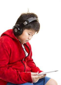 Side view vertical shot of a young Asian boy in red listening to music with a headphone isolated on white.