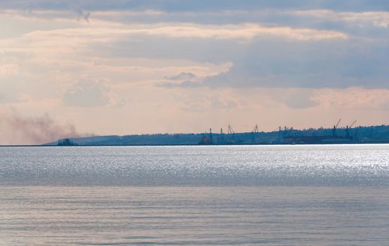 Port near metallurgical works with smoke with Azov sea on front. Mariupol, Ukraine