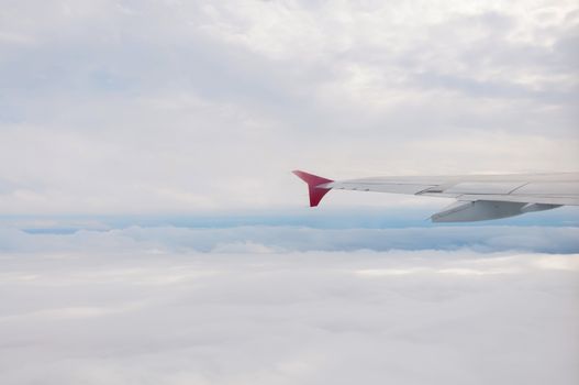 Winf of airplane above fluffy white cloudscape