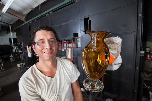 Handsome Hispanic man holding yellow vase on rod