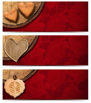 Handmade wooden hearts hanging from a section of tree trunk on red velvet background with roses flowers
