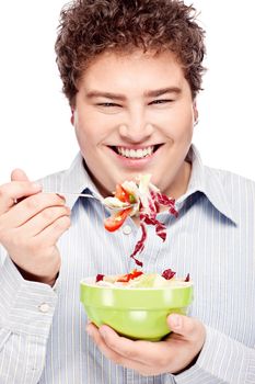 Happy young chubby man with fresh salad in dish, isolate on white