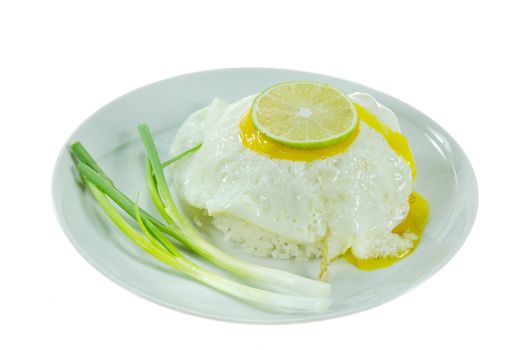 steamed  rice and fried egg with fresh vegetable on white dish over white background