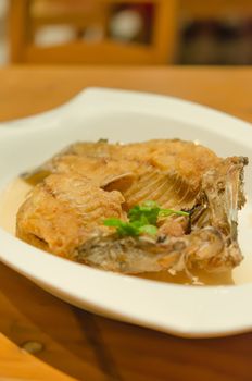 Fish dish - fried fish fillet on white dish (selective focus) 