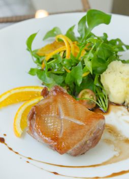 close up roasted duck breast  served with mashed potatoes and slice orange , fresh vegetable and white wine sauce