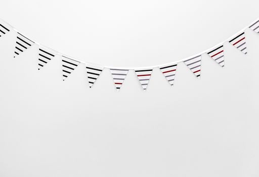 Striped bunting flags decorating an empty white wall.