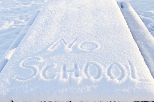 No School carefully printed in fresh snow indicates winter weather has closed local schools. 