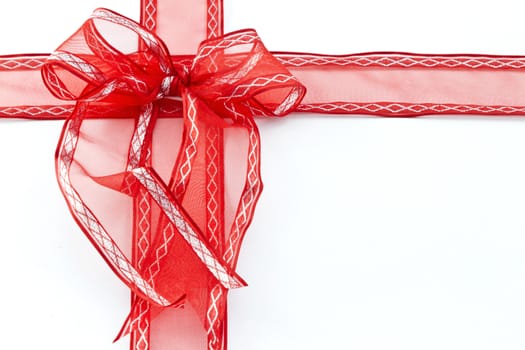 Red ribbon placed as rectangular gift box on white background with copy space on right;