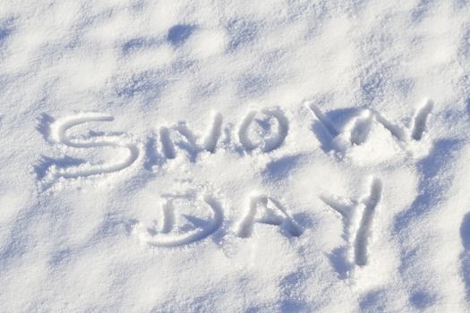 Snow Day written in capital letters in fresh snowfall signifies No School