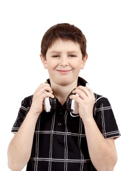 Portrait of a happy smiling young boy listening to music on headphones against white background 