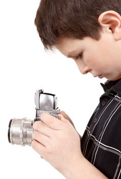 young boy with old vintage analog SLR camera looking to viewfinder