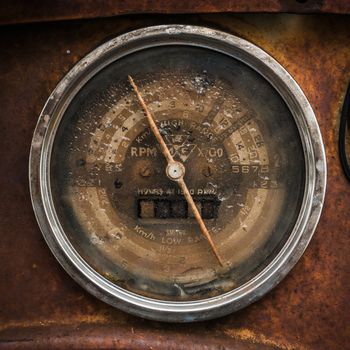 Vintage car speedometer on a rusty steel background