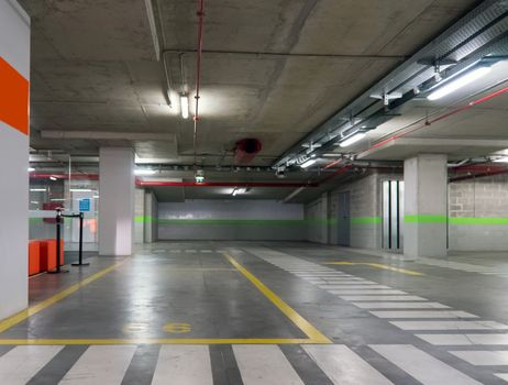 Parking garage underground, industrial interior.  Neon light in bright industrial building.