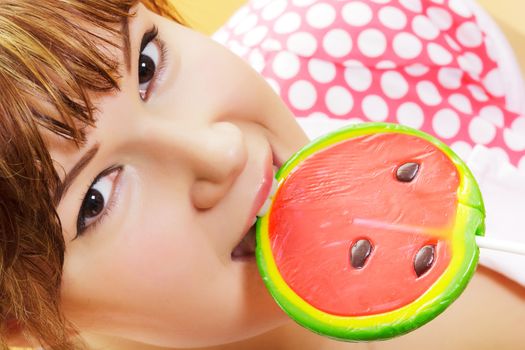 attractive brown-eyed girl with a round lollipop