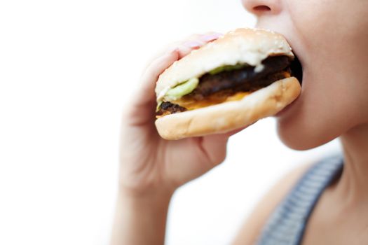 Woman eating hamburger. Side view