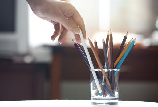 Human hand taking pencil in artist room
