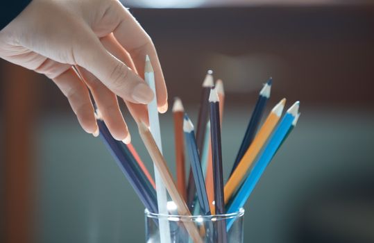 Human hand choosing pencil in artist studio