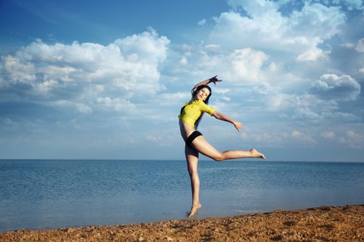 Dancing and jumping lady on the summer beach