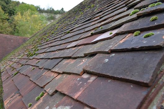 Overlapping red clay roof tiles on a building in England.