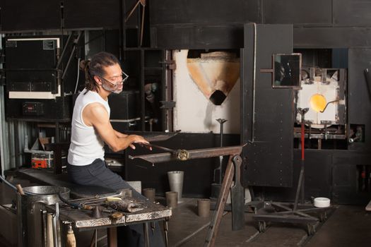 Mature male sitting near blast furnace with fine art glass