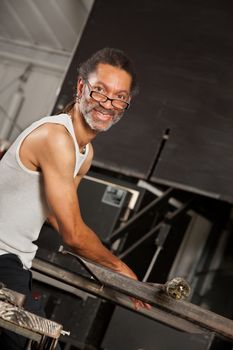 Confident Black glass artisan working on metal workbench