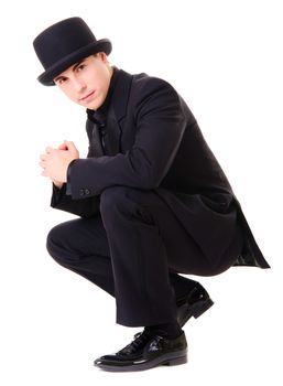 Young attractive man in black suit and hat isolated on white background