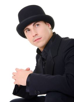 Young attractive man in black suit and hat is looking up isolated on white background