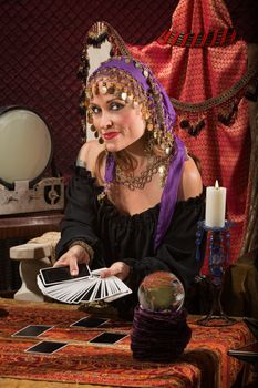 Beautiful Roma woman with crystal ball and tarot cards