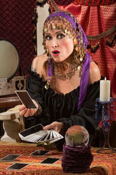 Startled tarot card reader with crystal ball and candle