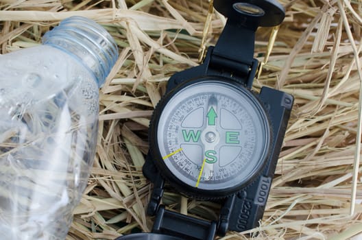 compass with blank water bottle on the hay