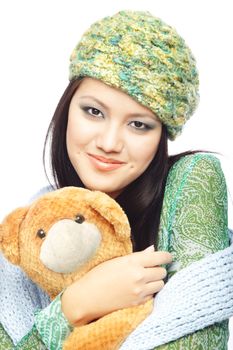 Smiling lady in the stylish winter clothes and cap holding Teddy bear on a white background