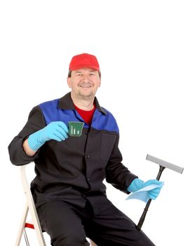 Man in workwear sitting and drinking a cup of coffee. Isolated on a white background.