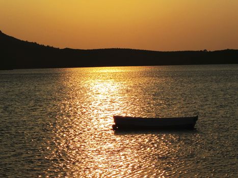 A small boat in front of a wonderful sunset