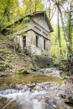 Picture of a old house and creek in a forest in autumn