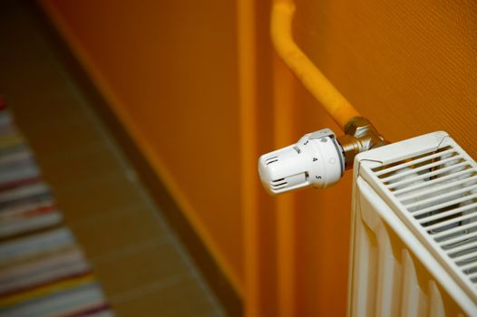 Heating radiator detail against orange wall