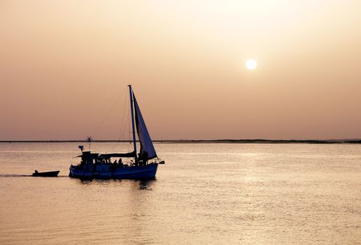 Recreation boat at sunset, in Ria Formosa, natural conservation region in Algarve, Portugal. 