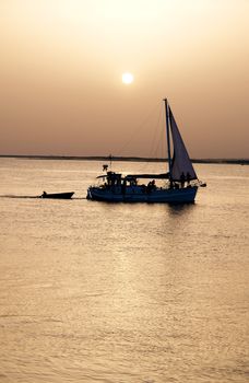 Recreation boat at sunset, in Ria Formosa, natural conservation region in Algarve, Portugal. 