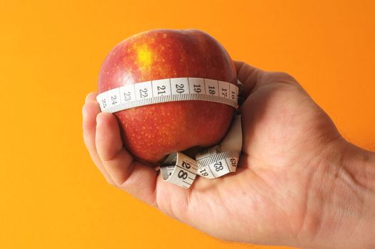 Diet Apple and Meter on the Hand on a Colored Background 