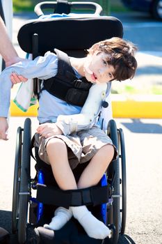 Young disabled child in wheelchair. Child has cerebral palsy.