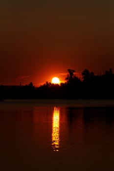 Colorful sunset over tranquil water surface.