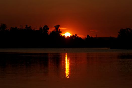 Colorful sunset over tranquil water surface.