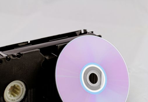 VHS video tape and DVD disk (analog digital) on white background