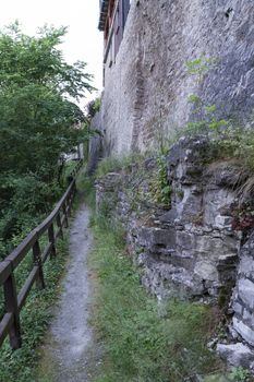 narrow foot path near the historic town of Vellberg, Germany. Steep wall at right side