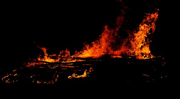 red flames of huge bonfire or campfire as black backgorund