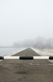 road to far away with barrier on freeze hoarfrosted landscape