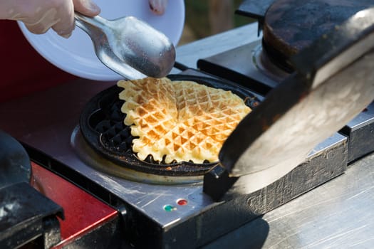 Waffle iron in the kitchen. Preparing homemade waffles.