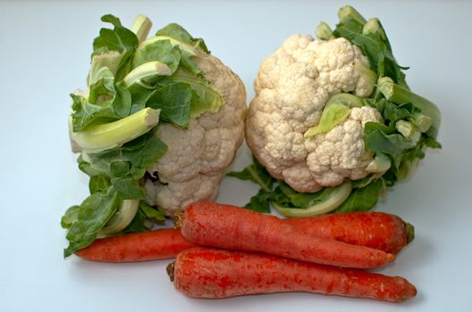 Freshly cut cauliflower cabbage and carrots  isolated on white .