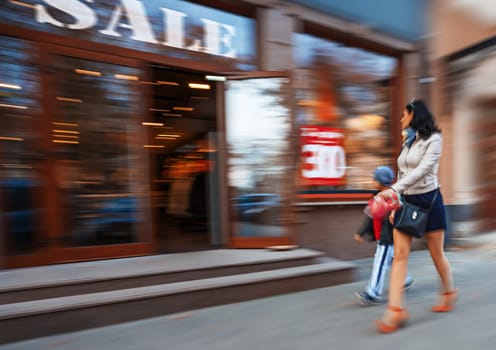 Mother and son shopping in mall. Intentional motion blur